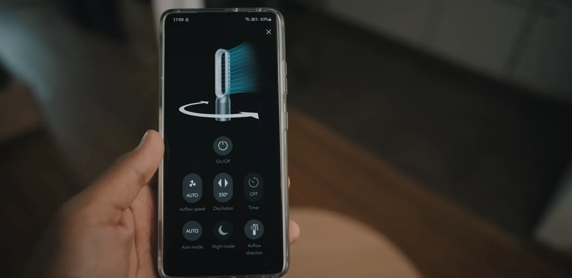 Utilizator ținând în mână un smartphone cu aplicația MyDyson deschisă pentru a controla purificatorul TP09