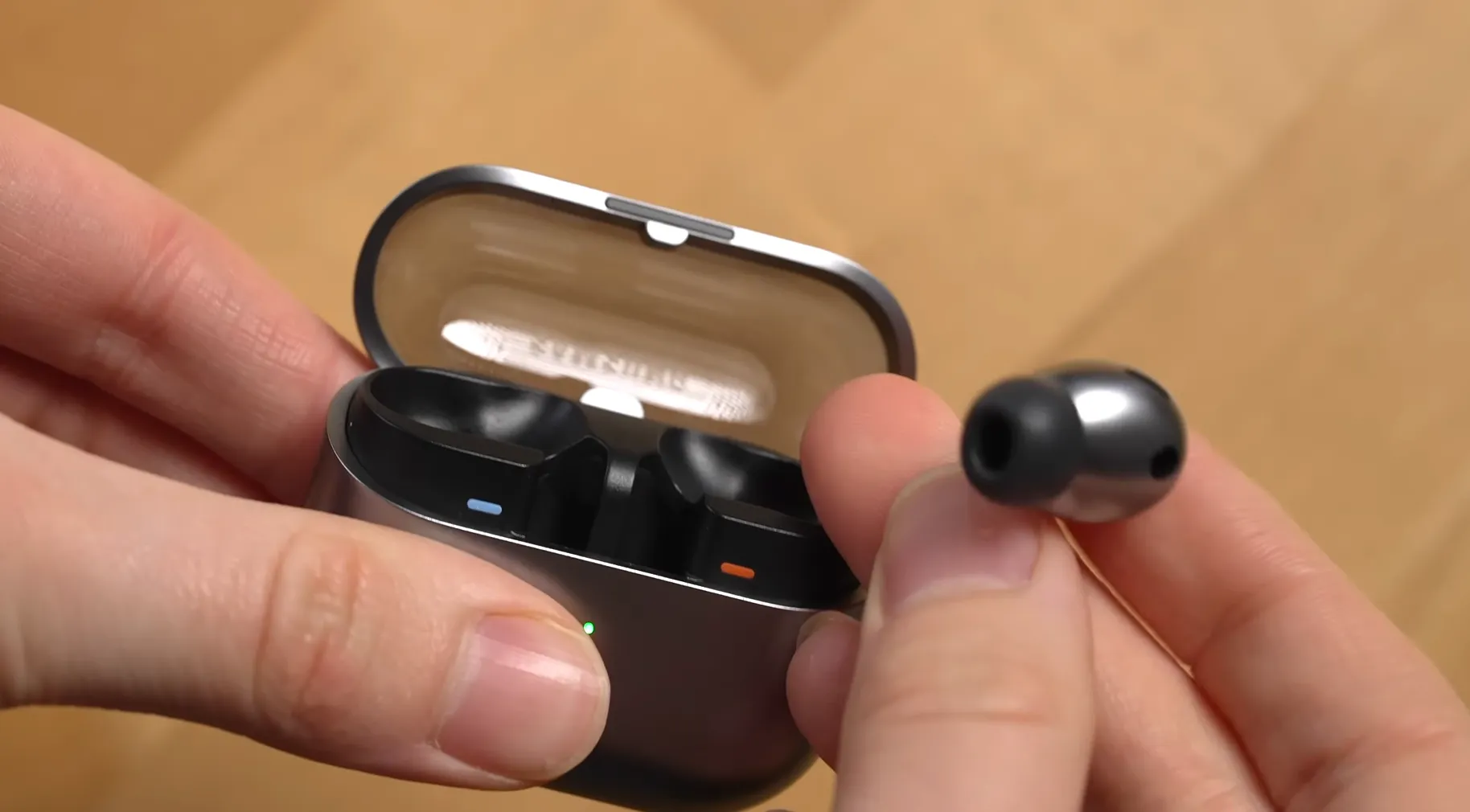 Utilizator scoțând casca Samsung Galaxy Buds3 Pro din carcasă, arătând dopul din silicon specific designului in-ear