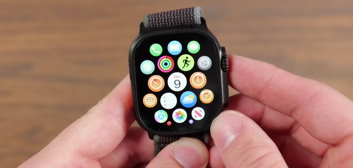 Utilizator navigând prin meniul principal de aplicații tip fagure pe ecranul Apple Watch Ultra 3