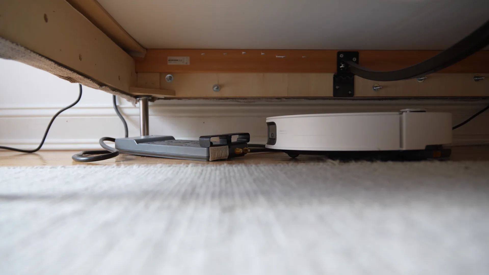 Roborock Saros 10 navigând în spații înguste sub mobilă datorită profilului redus