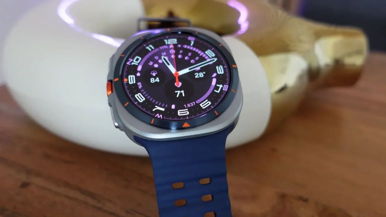 Prim-plan cu ceasul Samsung Galaxy Watch Ultra, carcasă din titan gri și butonul lateral portocaliu Quick Button