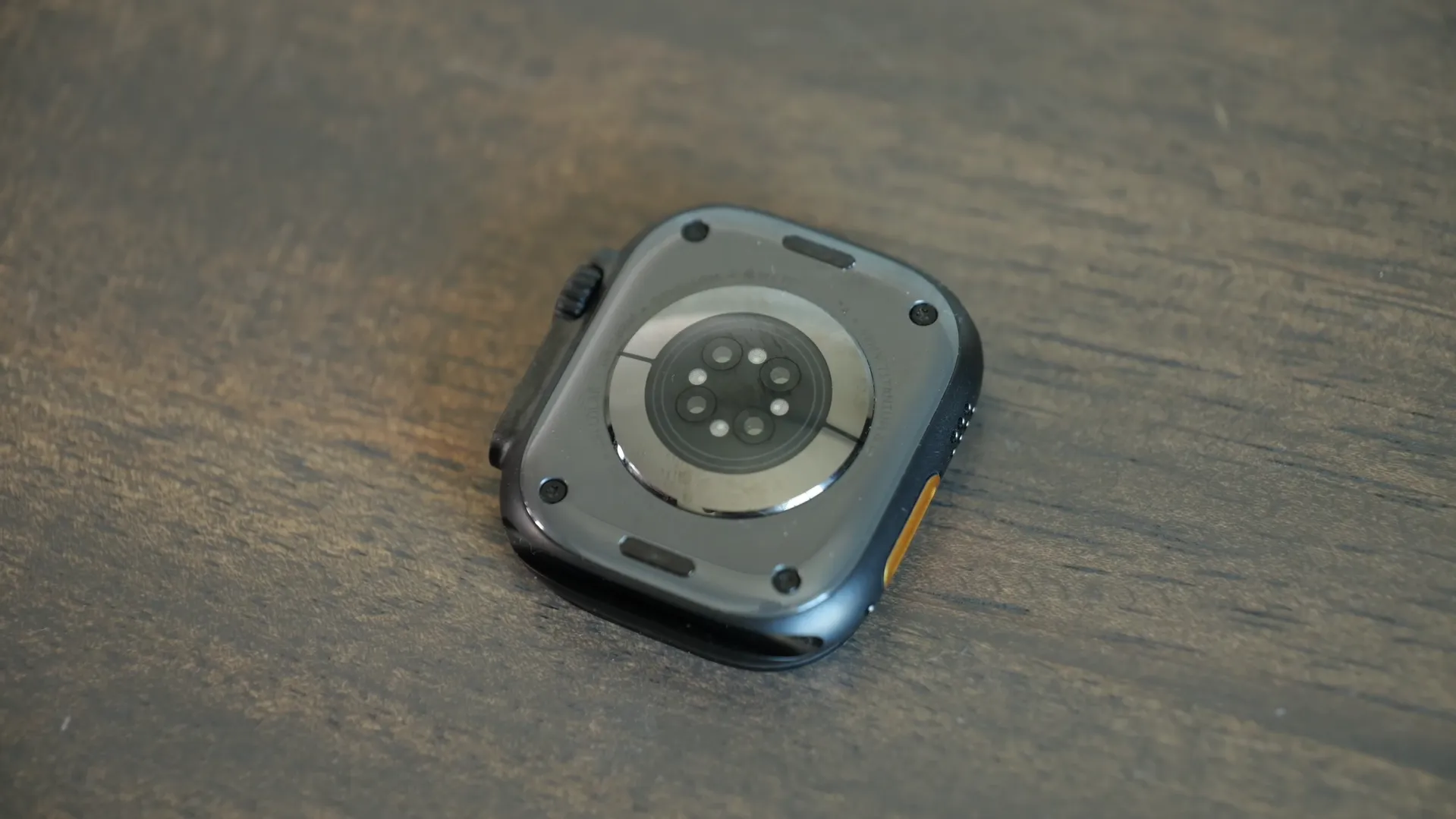 Spatele ceasului Apple Watch Ultra 3 afișând senzorii optici, inelul ceramic și prinderile curelei