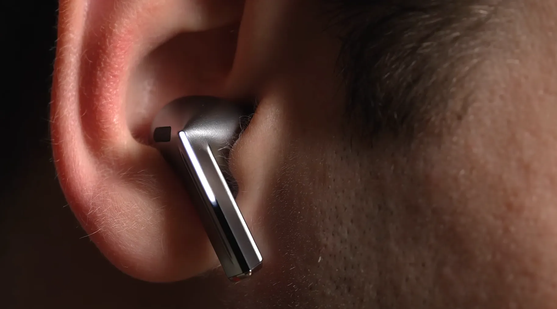 Casca argintie Samsung Galaxy Buds3 Pro purtată în ureche, demonstrând noul design cu tijă unghiulară