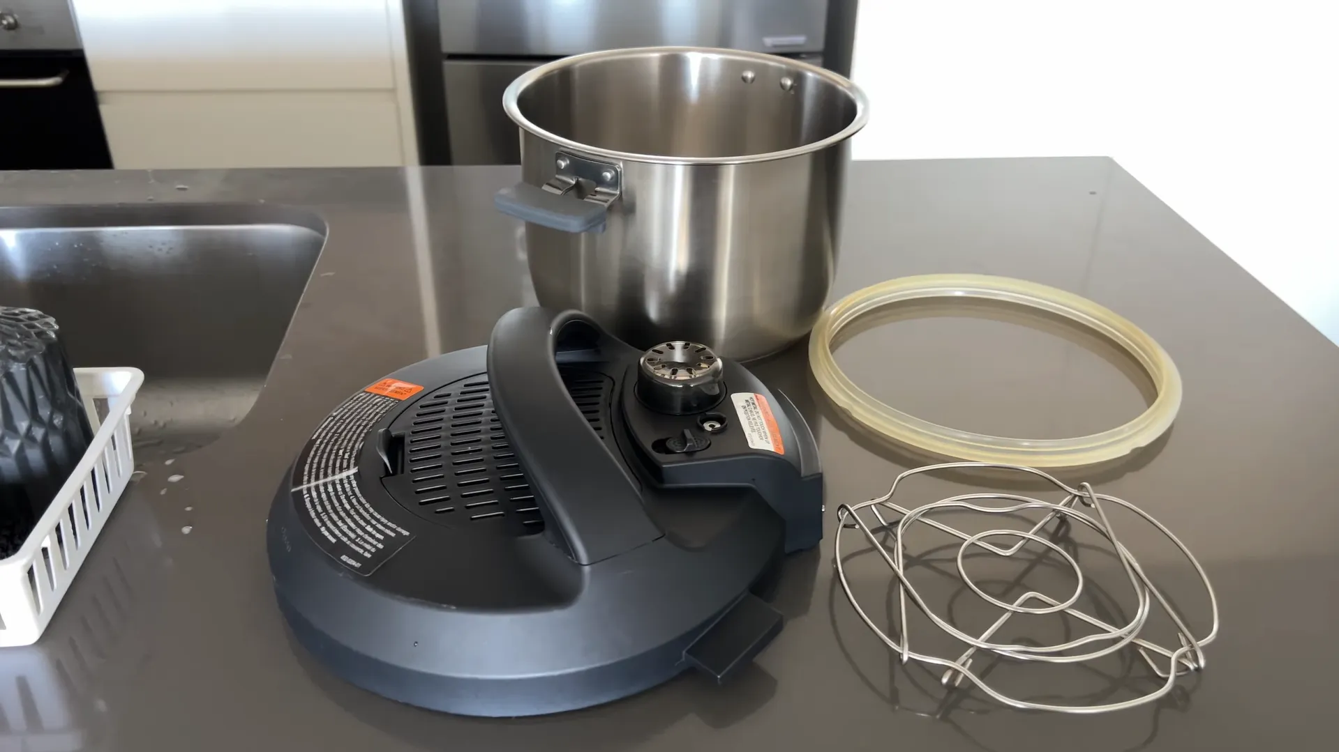 Componentele desfăcute ale aparatului Instant Pot Pro 8: capacul, oala din inox, inelul de silicon suplimentar și grătarul