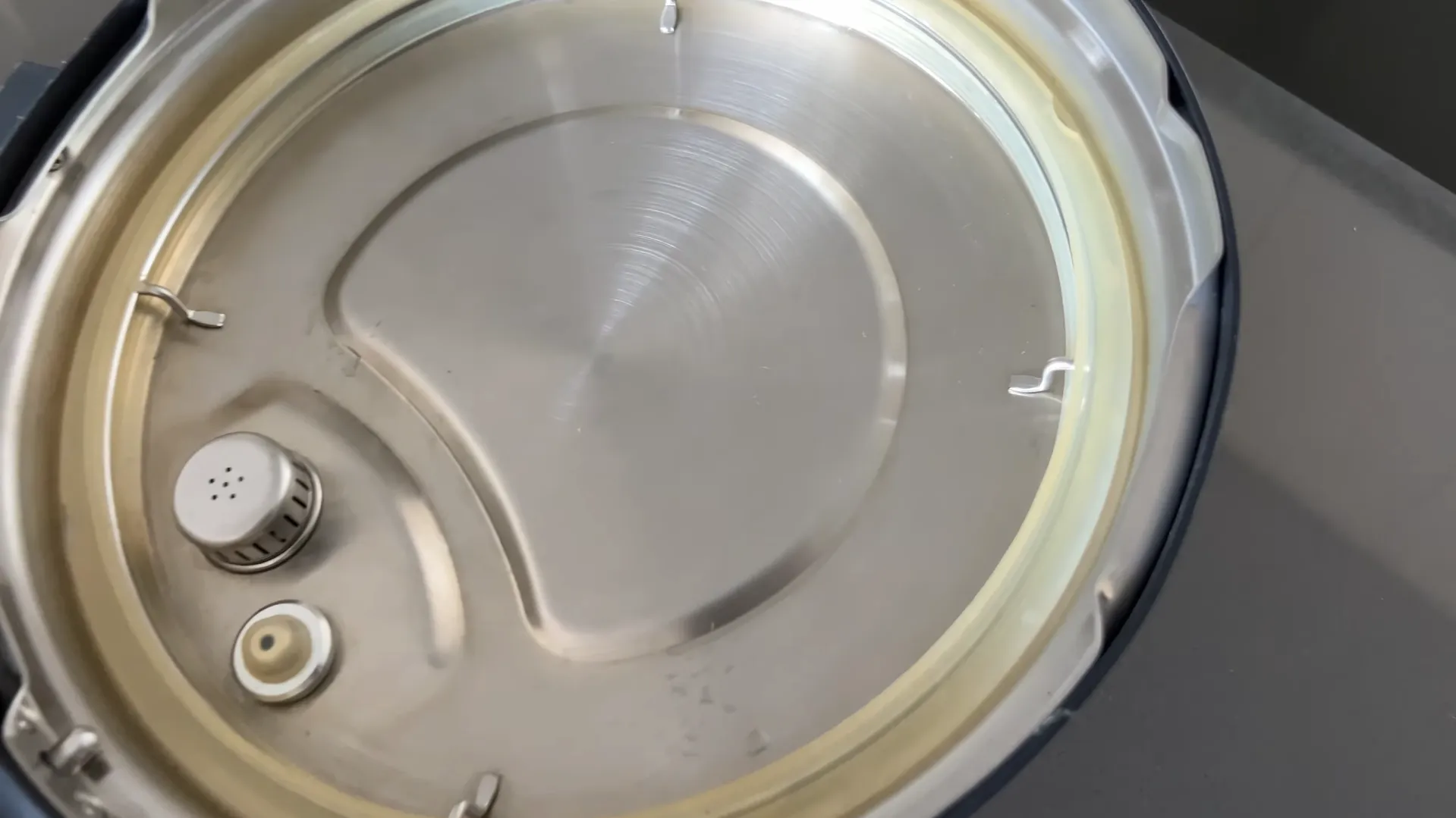 Partea inferioară a capacului din inox de la Instant Pot Pro 8, arătând garnitura de silicon de etanșare și scutul antiblocare